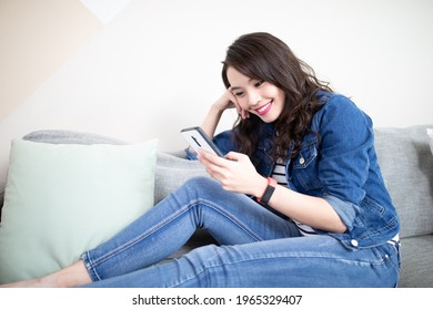 asian woman use smart phone and smile happily at home