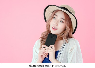 Asian woman use smartphone to online shopping, summer holiday clothing, pink background