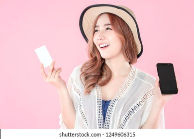 Asian woman use smartphone to payment online shopping with blank credit card, summer holiday, pink background