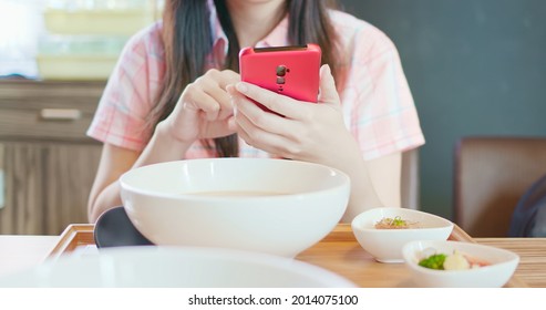 Asian Woman Use Smartphone In Restaurant Before She Eat Ramen