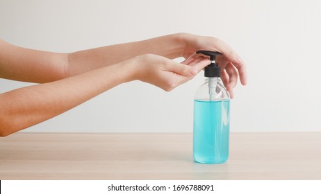 Asian Woman Using Alcohol Gel Hand Sanitizer Wash Hand For Protect Coronavirus. Female Push Alcohol Bottle To Clean Hand For Hygiene In Social Distancing And Self Quarantine Time.