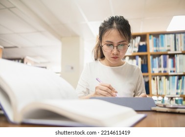 Asian Woman Using Digital Tablet To Research, Library Information, Adult Education Concept.