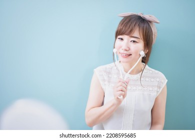 Asian Woman Using Facial Roller