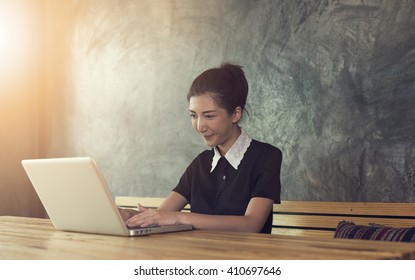 Asian Woman Using Laptop In Cafe