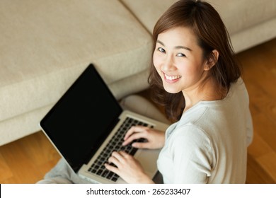 Asian Woman Using Laptop At Home