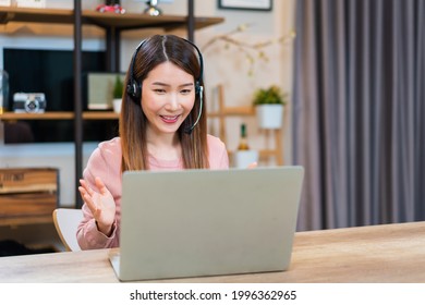 Asian Woman Using Laptop Making Video Call For Distant Meeting Or Online Support Working From Home While Coronavirus Pandemic