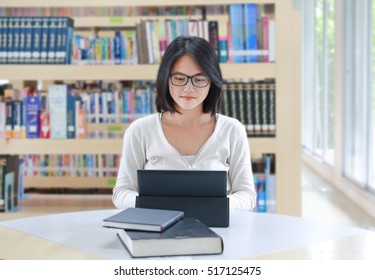 Asian woman using notebook in the library.