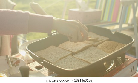 Asian Woman Using Pan For Toast Bread In The Morning.Prepare Food For Breakfast 