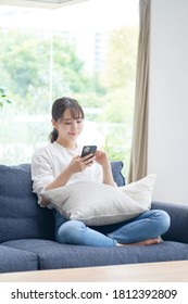 Asian Woman Using The Smart Phone  At Home