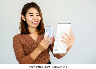 Asiatische Frau, die Smartphone-Scan QR-Code auf Stromrechnung, um online zu bezahlen 