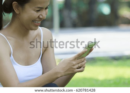 Asian woman using smart phone in park