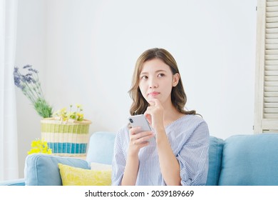 Asian Woman Using The Smartphone At Home