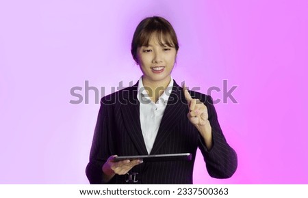 Asian woman using tablet connecting online clicking on virtual screen pink background.