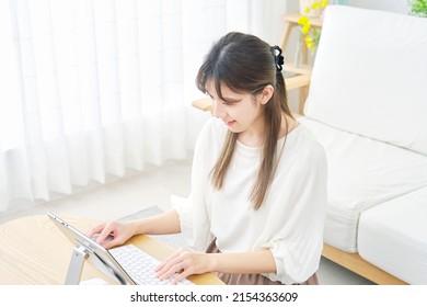 Asian Woman Using The Tablet At Home