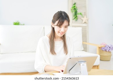 Asian Woman Using The Tablet At Home