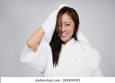 Asian Woman Is Using A Towel To Dry Her Hair After The Shower. On A White Background.