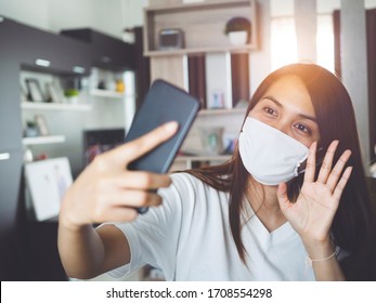 Asian woman video calling with smartphone at home, meeting online by app, social distancing, work from home, Stop the spread of the coronavirus or covid-19 concept.