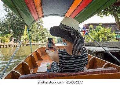 Asian Woman Visiting The Floating Market In Bangkok On A Boat Tour