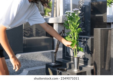Asian woman visiting a grave - Shutterstock ID 2349071011