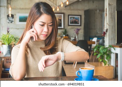 Asian woman waiting for someone who late appointment in coffee shop