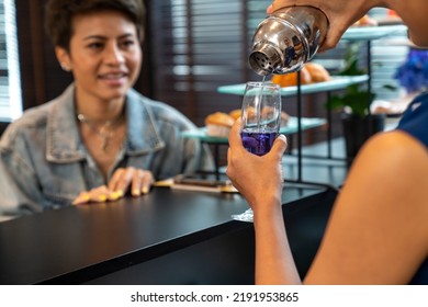 Asian Woman Waitress Serving Soft Drink To Female Tourist At Airport Private Lounge While Waiting For Boarding In Airport Terminal. Airline Service Business And Airplane Transportation Concept