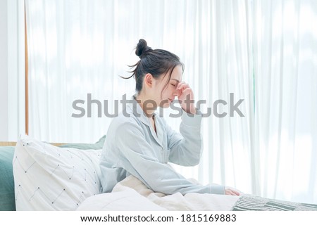Asian woman waking up with headaches