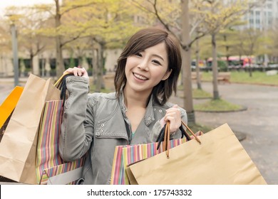 Asian Woman Walk And Hold Shopping Bags At Street After Raining In Taipei, Taiwan,  Asia.