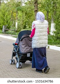 Asian Woman Walking With A Big Pram In The Park