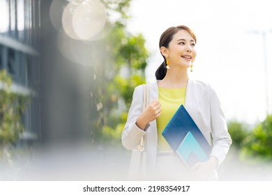Asian woman walking in the park. - Shutterstock ID 2198354917