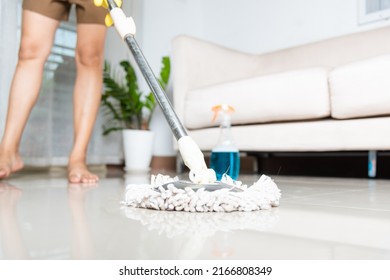 Asian Woman Washes The Floor With A Mop And Rag Indoors, Housewife Washing Floor Mopping At Home In Living Room Cleaning Her Home, Professional Housekeeping Job House Cleanup Concept