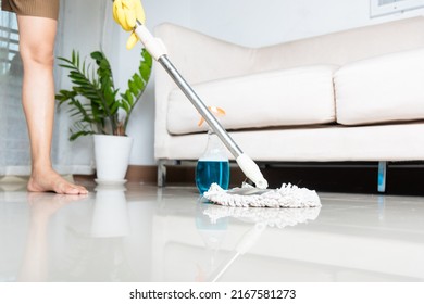 Asian Woman Washes The Floor With A Mop And Rag Indoors, Housewife Washing Floor Mopping At Home In Living Room Cleaning Her Home, Professional Housekeeping Job House Cleanup Concept