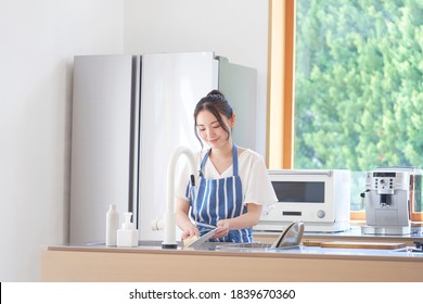 Asian woman washing the dish - Powered by Shutterstock