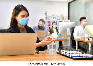 Asian Woman Washing Hands Sanitizer Gel And Wearing Face Mask Working In New Normal Office And Doing Social Distancing During Corona Virus Covid-19 Pandemic