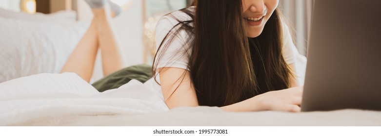 Asian Woman Watching Streaming Series In  Laptop Computer, Lying In The Bed At Home.