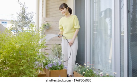 Asian Woman Watering The Garden