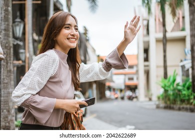 Asian Woman Wave Her Hand While Waiting For Taxi