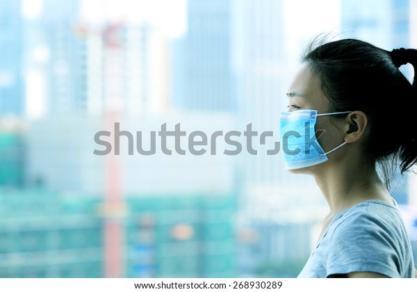 Asian woman wear\
face mask in pollution\
city