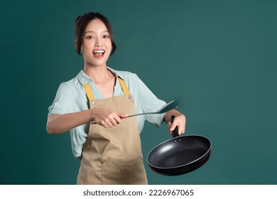 Asian woman wearing apron and holding a pan - Powered by Shutterstock