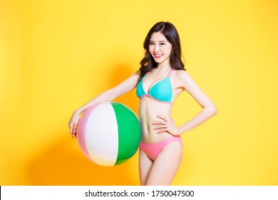 asian woman wearing bikini swimsuit with beach ball