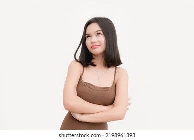 An Asian Woman Wearing A Brown Tank Top Showing Sarcasm, Rolling Her Eyes In Disbelief Isolated On A White Background. Stonewalling Someone.