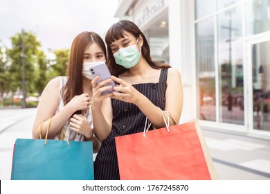 Asian Woman Wearing Face Mask. Happy Woman With Shopping Bags Enjoying In Shopping. Girl Holding Colour Paper Bag.Friends Walking In Shopping Mall.time Shopping Coronavirus Crisis Or Covid19 Outbreak