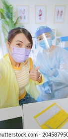 Asian Woman Wearing Face Mask Taking Selfie While Receiving Coronavirus Vaccine - Smiling Girl And Nurse Are Showing Thumbs Up After Got COVID-19 Vaccination