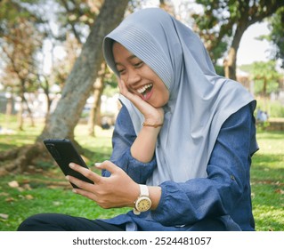 Asian woman wearing hijab sitting in park, video call with someone, smiling very happy cheerful expression



 - Powered by Shutterstock