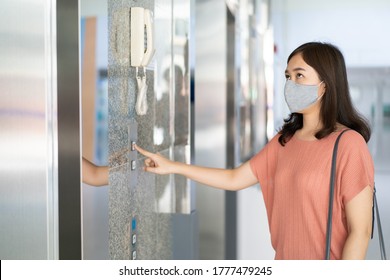 Asian woman wearing a hygiene protective face mask while using the elevator, woman pressing on a elevator button close up. - Powered by Shutterstock