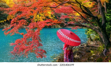 Asian woman wearing japanese traditional kimono at Arashiyama in autumn season along the river in Kyoto, Japan.
