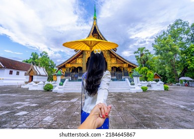 Asian Woman Wearing A Lao National Costume Visits Wat Xieng Thong In Luang Prabang, Laos