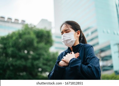 Asian woman wearing mask can't breath while wearing mask walking in the city. - Powered by Shutterstock