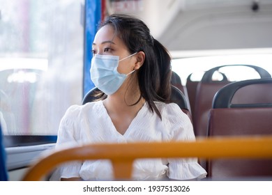 Asian Woman Wearing A Mask, She's On A Public Bus