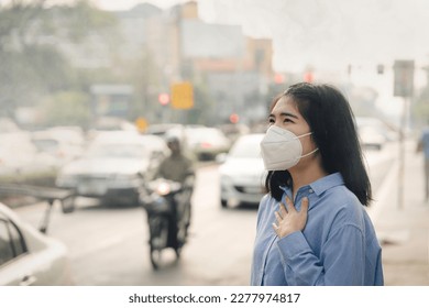 Asian woman wearing the N95 Respiratory Protection Mask against PM2.5 air pollution and headache Suffocate. City air pollution concept