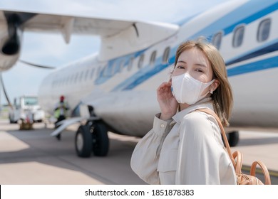 Asian Woman Wearing Protective Face Mask During Covid-19 Virus Pandemic,  Walks To Stair Entering Airplane, Parking Outside Terminal In Airport.